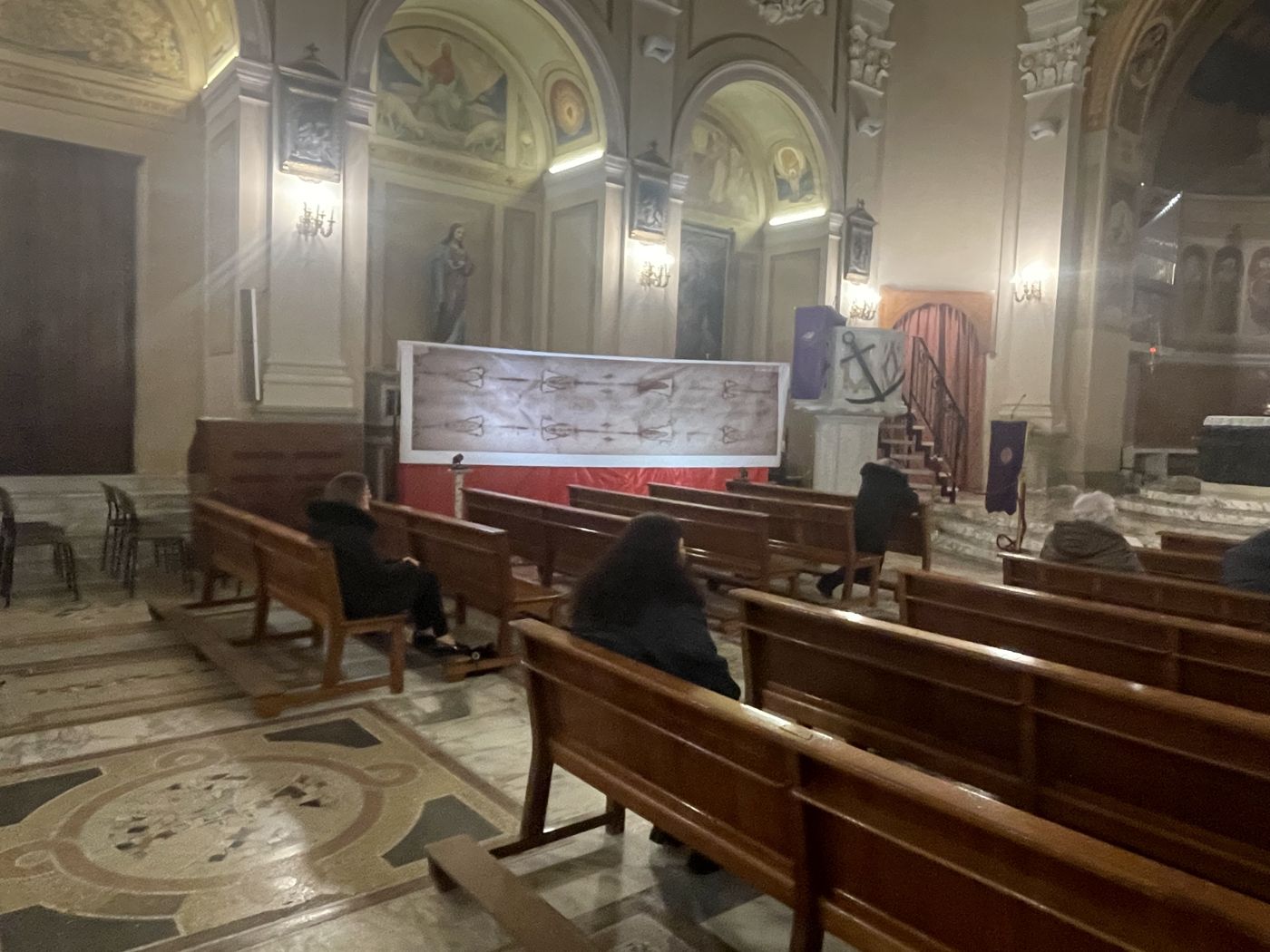 Navata dell'Abbaziale di Bagnara Calabra con la copia della Sindone esposta e i fedeli tra i banchi